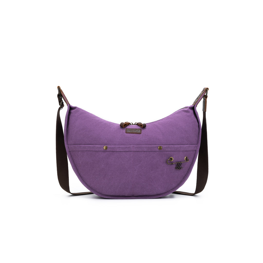 A crescent-shaped project bag in rich plum purple with dark brown adjustable strap and leather detailing.