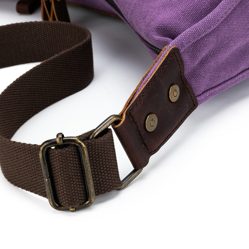 Close-up of the adjustable canvas strap and leather attachment of a della Q bag, showcasing brass hardware.